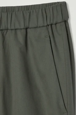 Fashion COS ZWĘŻANE SPODNIE Z TKANINY O SPLOCIE SKOŚNYM Ciemnozielony